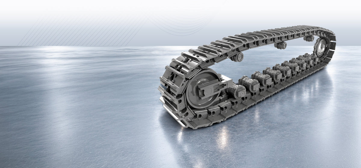 Tracked undercarriage assembly with steel track shoes, rollers and idler on a grey display floor.